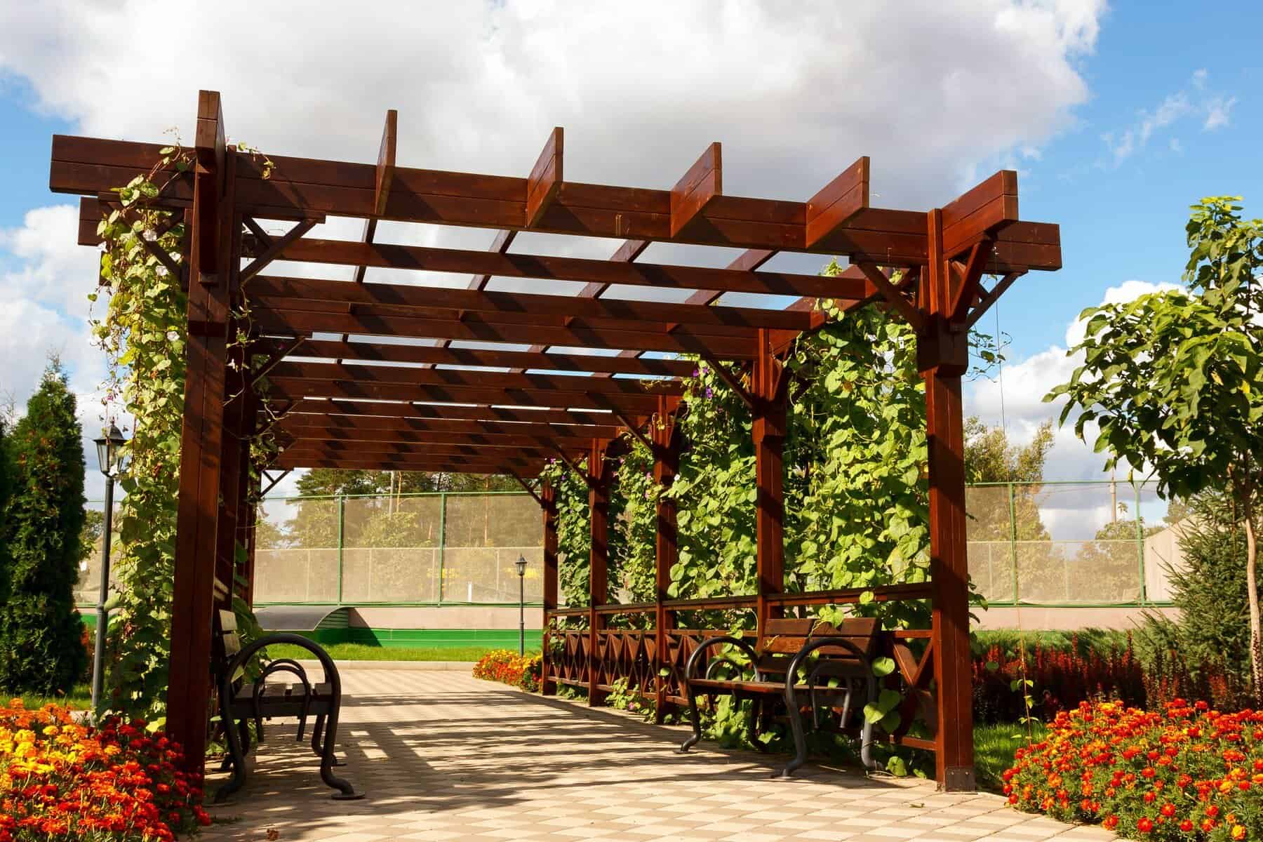 a wooden structure with benches and a fence- Pergola and Gazebo Painters