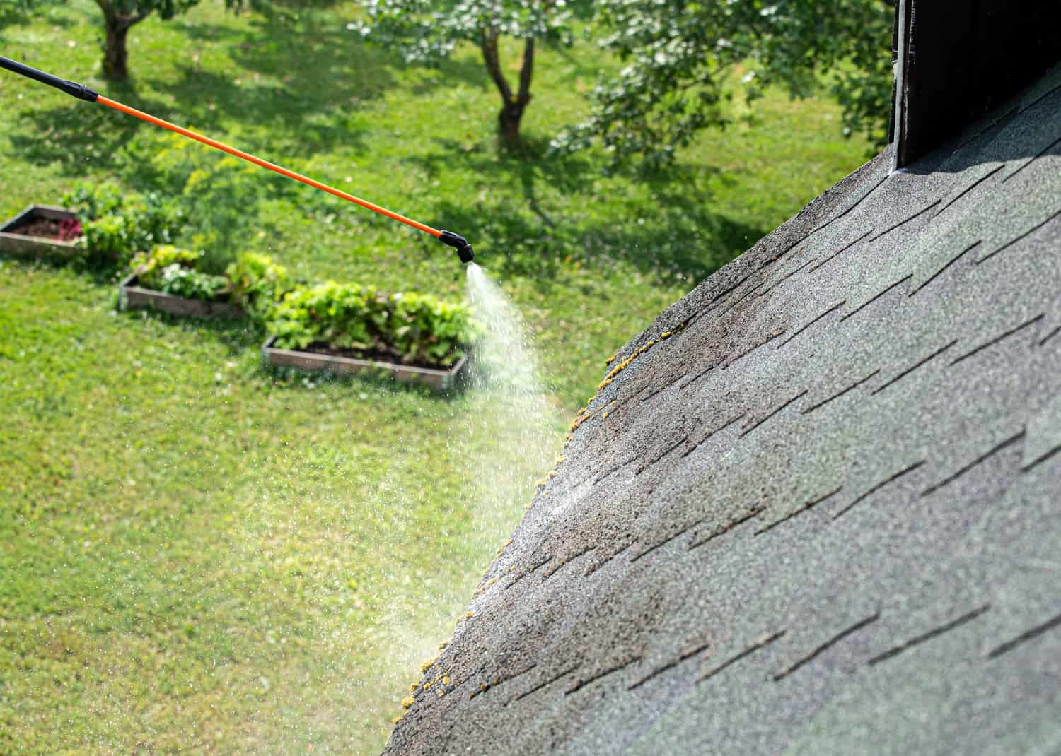 a spraying a roof with a hose- Pressure Washing in fort mill sc