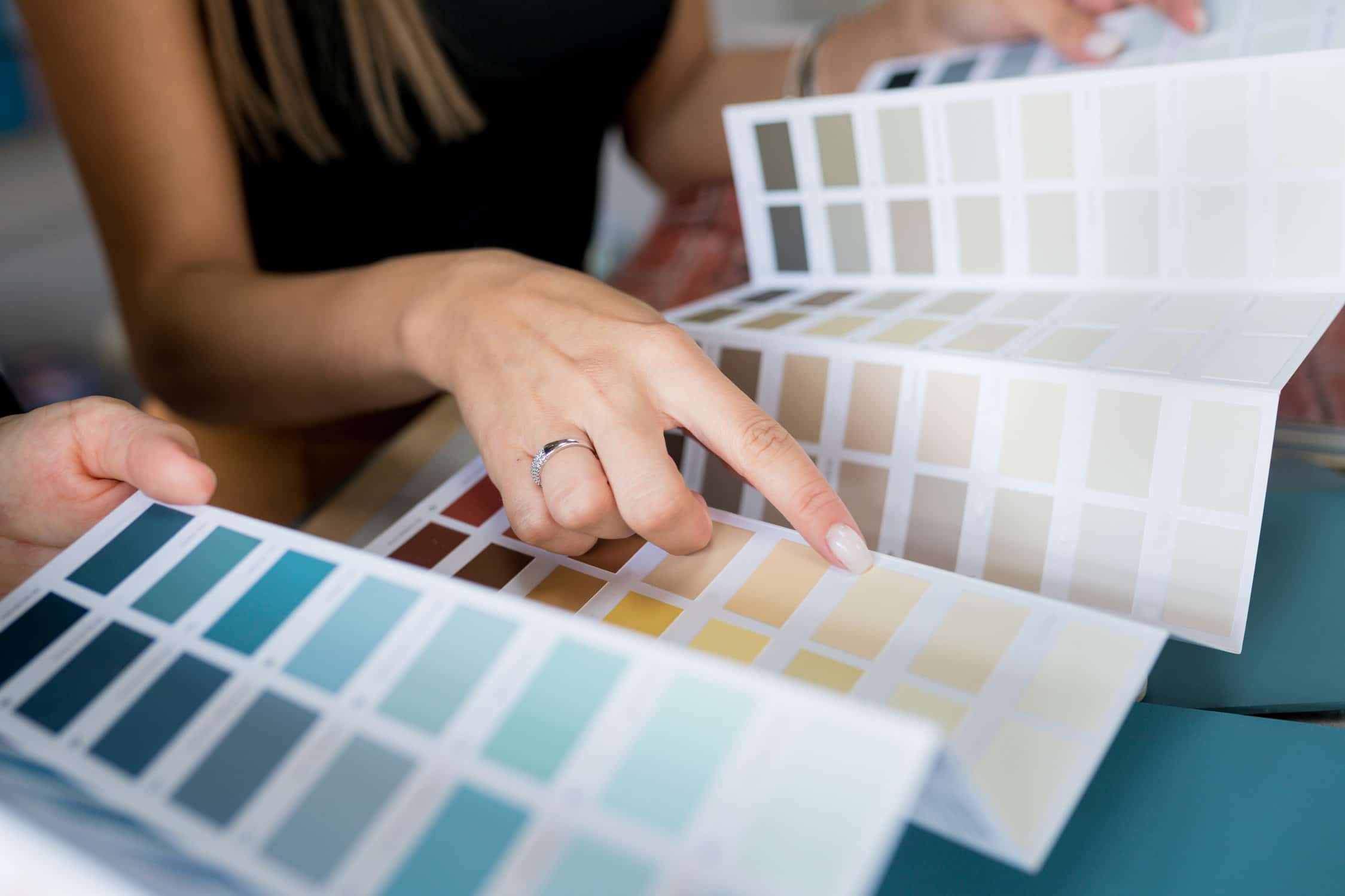 Close-up of two women choosing samples of wall paint- what type of paint is best for high-traffic areas