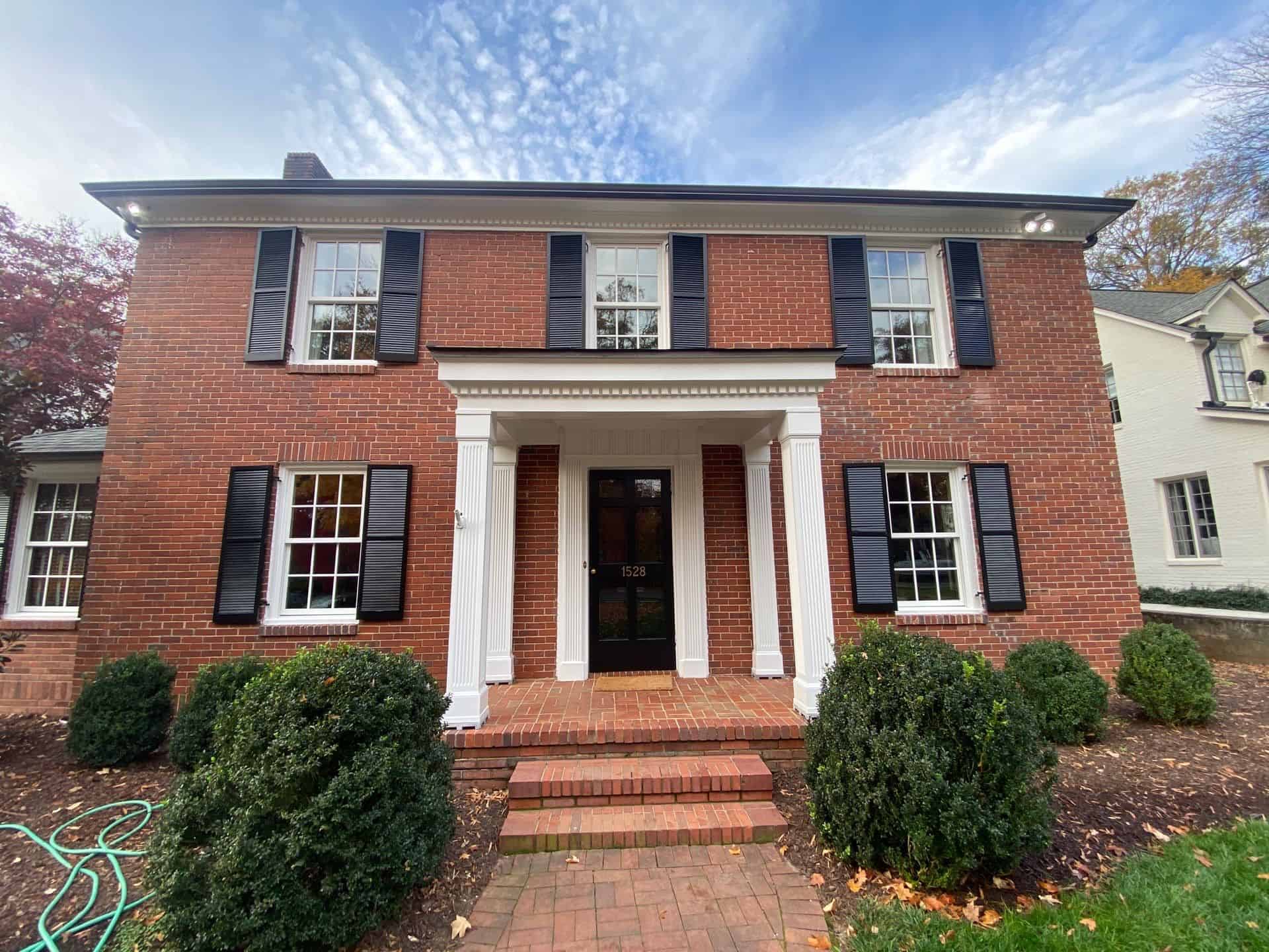 a brick house with a brick walkway- residential painting company in charlotte nc
