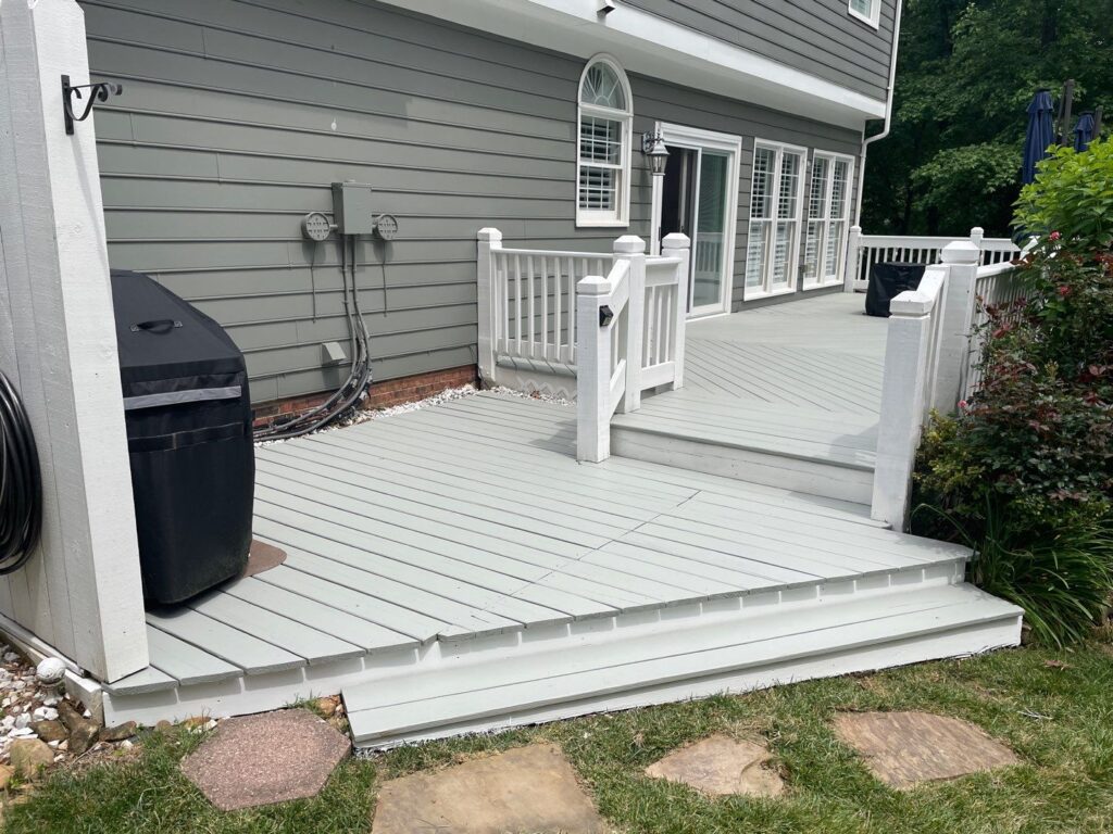a deck with a white railing and a blue umbrella- exterior house painters in charlotte nc
