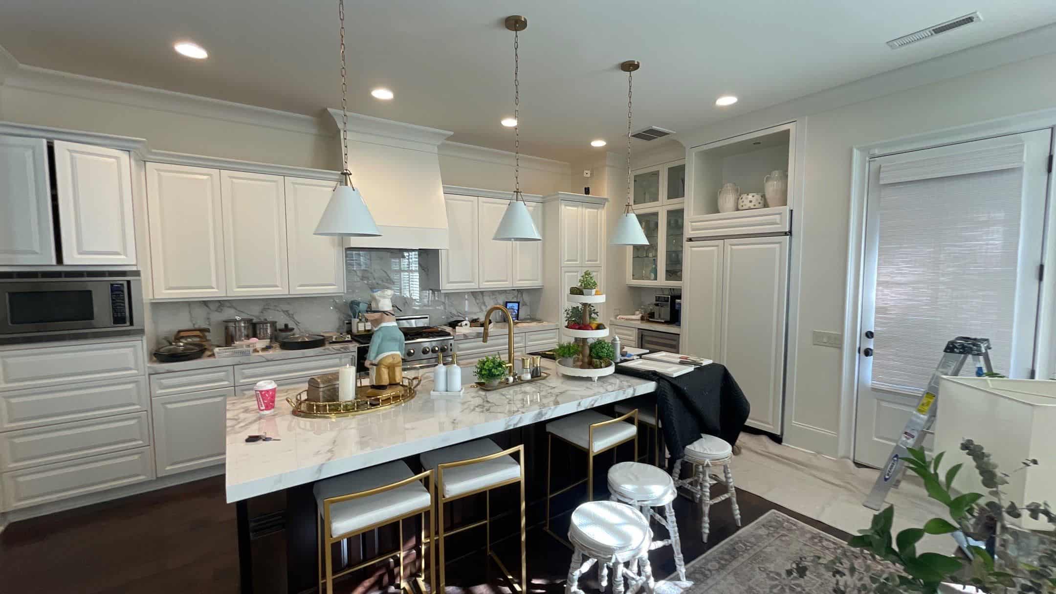 a kitchen with white cabinets and marble countertop- residential painters in fort mill sc