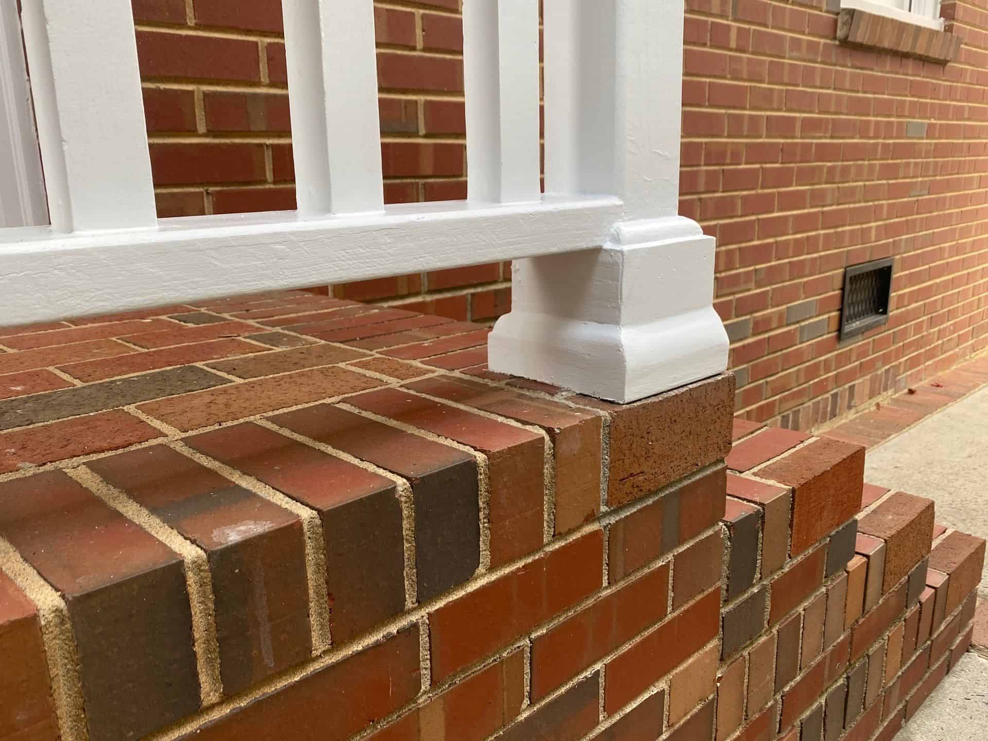 a brick wall with a white railing- marvin nc painters
